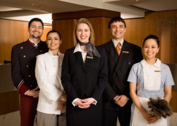 Hospitality industry workers providing excellent customer service at modern hotel front desk