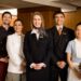 Horecamedewerkers die uitstekende klantenservice bieden bij de receptie van een modern hotel