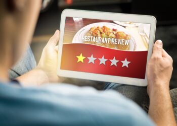 Restaurant professional using tablet to collect customer feedback and prevent negative reviews