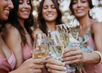 Elegant ladies toasting with glasses filled with golden grower champagne bubbles