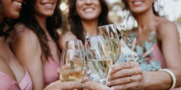 Elegant ladies toasting with glasses filled with golden grower champagne bubbles