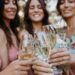 Elegant ladies toasting with glasses filled with golden grower champagne bubbles