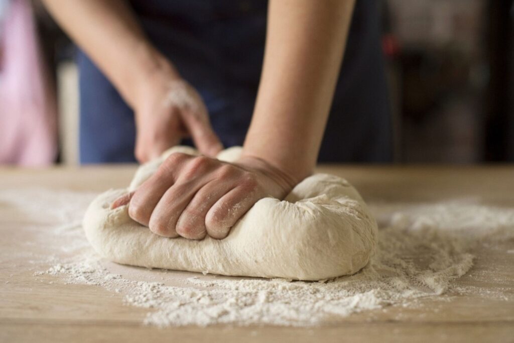 Home baker making artisan sourdough bread through wild yeast fermentation and traditional techniques