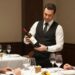 Restaurant wine program with professional sommelier presenting wine list and profitable bottle selection