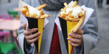 young lady with 2 cones belgian fries with mayonaise gusto webzine
