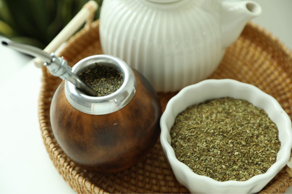 People sharing mate tea in gourd during uruguayan asado social gathering