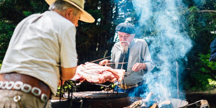 Traditional uruguayan asado meat grilling on parrilla with smoke and flames