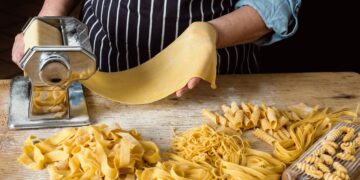 Frische Pasta-Nester mit Grießmehl bestäubt trocknen auf einer Holzoberfläche vor dem Kochen