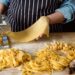 Nids de pâtes fraîches enfarinés à la semoule séchant sur une surface en bois avant la cuisson