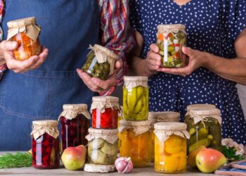 man and woman present fermented vegetables pots