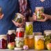 Mann und Frau präsentieren fermentierte Gemüsetöpfe