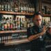 Ein erfahrener Barkeeper, der Mixologie-Techniken anwendet, während er einen handwerklich gefertigten Cocktail an einer Restaurantbar zubereitet