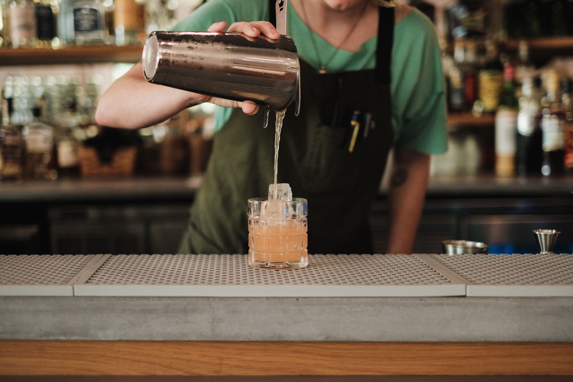 Ein Restaurantbarkeeper wendet Mixologie-Fähigkeiten an, um einen Saisoncocktail mit frischen lokalen Zutaten zu kreieren