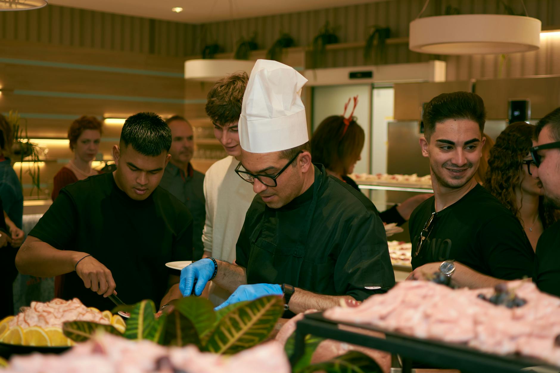 Ein Caterer serviert Gästen Speisen an einem Outdoor-Catering-Buffettisch, der für ein Unternehmensereignis aufgebaut wurde.