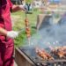 chef-setting-up-outdoor-catering-station-pexels - GUSTOwebzine プロのシェフが大規模オフサイトイベント中の屋外ケータリングステーションで給仕用の皿を配置しています。