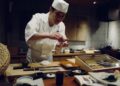 professional chef spreads miso paste onto a fillet in akitchen, showcasing miso as a versatile umami ingredient beyond soup.