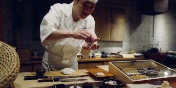professional chef spreads miso paste onto a fillet in akitchen, showcasing miso as a versatile umami ingredient beyond soup.