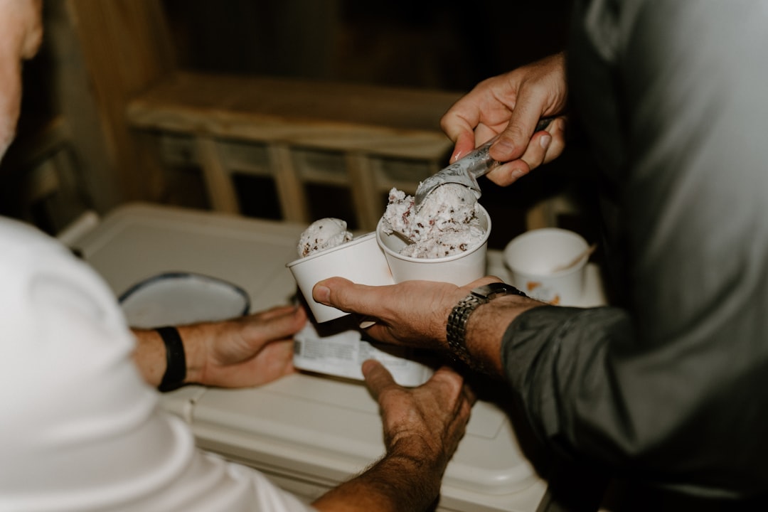 A family serving scoops of homemade ice cream into cones at a kitchen table together