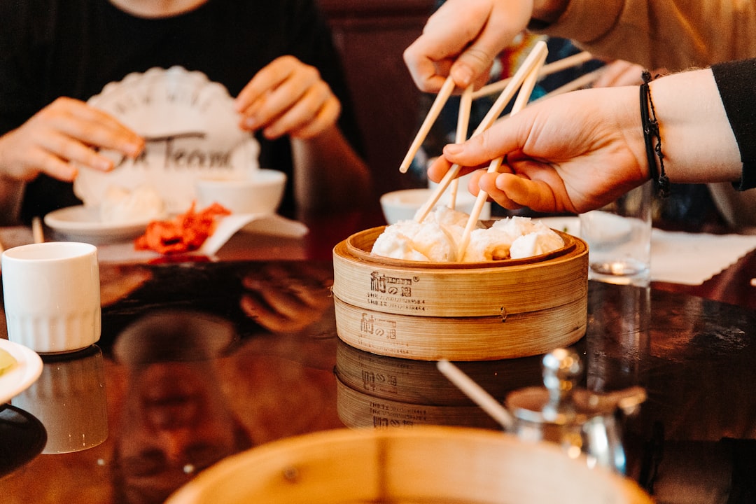 A family gathered around a table sharing a plate of dumplings, a scene that reflects the cultural tradition this dish carries