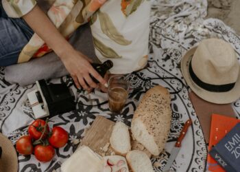 A woman arranges a traditional French picnic spread during a Bastille Day celebration outdoors
