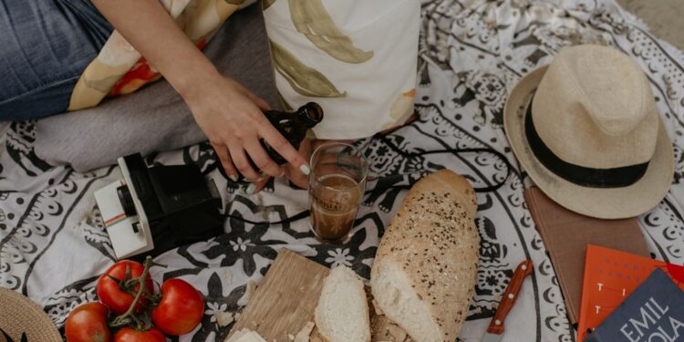 A woman arranges a traditional French picnic spread during a Bastille Day celebration outdoors