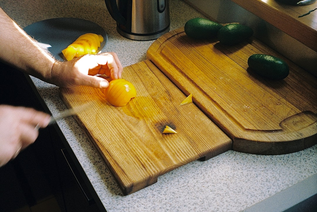 A person slicing ripe stone fruit and placing pieces into freezer bags for long-term preservation at home