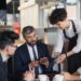 waiter-receiving-cash-tip-restaurant-pexels - GUSTOwebzine Ein lächelnder Kellner nimmt ein Bargeldtrinkgeld an einem Restauranttisch an und veranschaulicht Trinkgeldkulturen in einem gehobenen Restaurant.