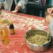 A woman folding handmade dumplings on a floured wooden surface, demonstrating the traditional craft behind this beloved dish