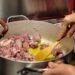 chef-braising-meat-unsplash - GUSTOwebzine Un chef cuidadosamente preparando braises lentos en una cocotte pesada, demostrando técnica clásica a fuego bajo