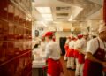 A hotel server guides a guest through an unfamiliar dish during staff training for global cuisines at a fine dining table