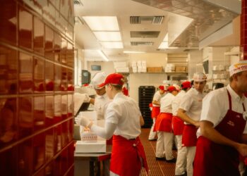 A hotel server guides a guest through an unfamiliar dish during staff training for global cuisines at a fine dining table
