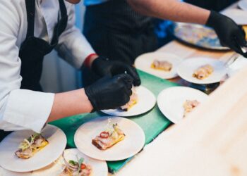 A food buyer tasting specialty food samples at a busy trade show booth in New York City