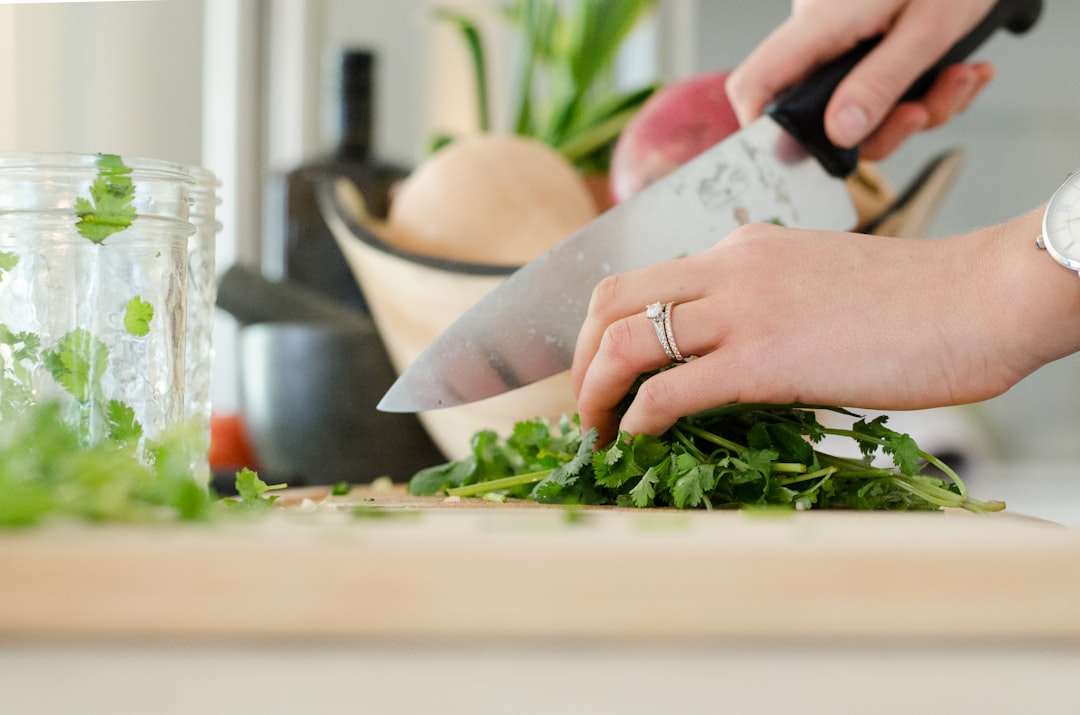 A home cook using the claw hand technique to practise knife skills while cutting summer produce