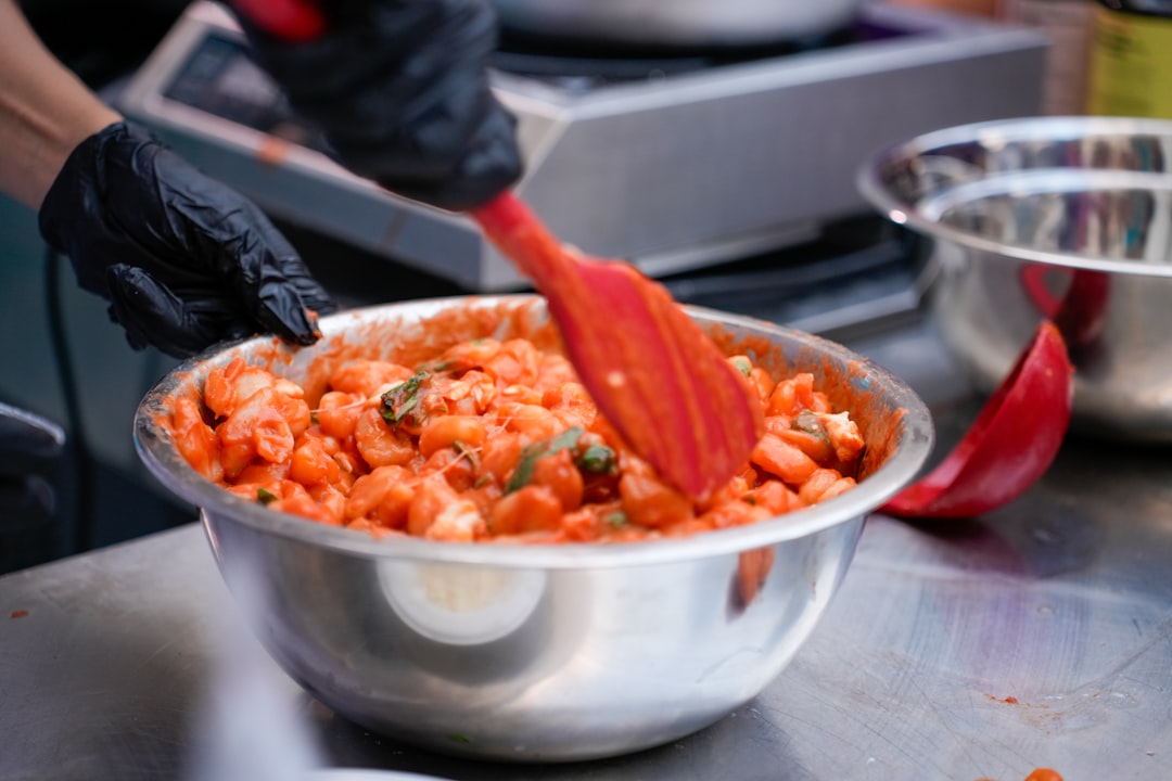 Una mujer prepara platos clásicos de tomate sobre la estufa en una luminosa cocina mediterránea