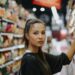 Japanese food labels hidden gluten guide - GUSTOwebzine Woman shopping in a supermarket aisle, reaching to grab an item from the shelf.