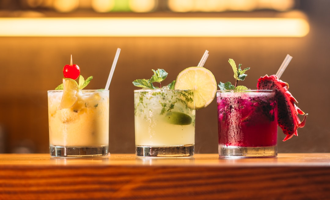 A bartender presenting a flight of fermented drinks to guests at a restaurant table decorated with autumn elements