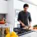 chef-chopping-herbs-kitchen-unsplash - GUSTOwebzine Een professionele chef die vers peterselie fijnhakt om een klassieke groene saus op een houten aanrecht klaar te maken