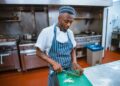 A chef plates a course during service, embodying the deliberate craft behind tasting menus that tell a seasonal story.