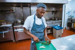 A chef plates a course during service, embodying the deliberate craft behind tasting menus that tell a seasonal story.