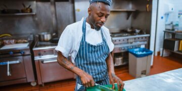 A chef plates a course during service, embodying the deliberate craft behind tasting menus that tell a seasonal story.