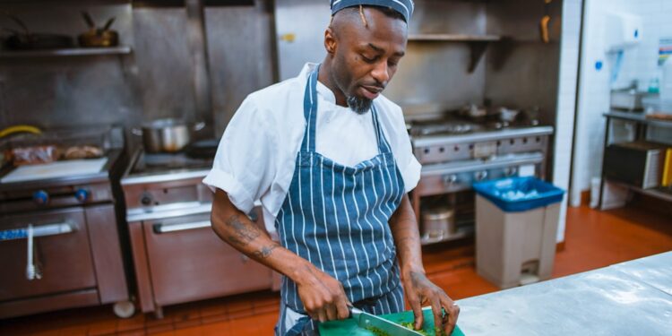 Un chef dresse un plat pendant le service, incarnant l'artisanat délibéré derrière les menus dégustation qui racontent une histoire saisonnière.