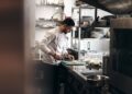 A chef monitors a tray of tomatoes and mushrooms, using key techniques to build deep flavour in a meatless dish.