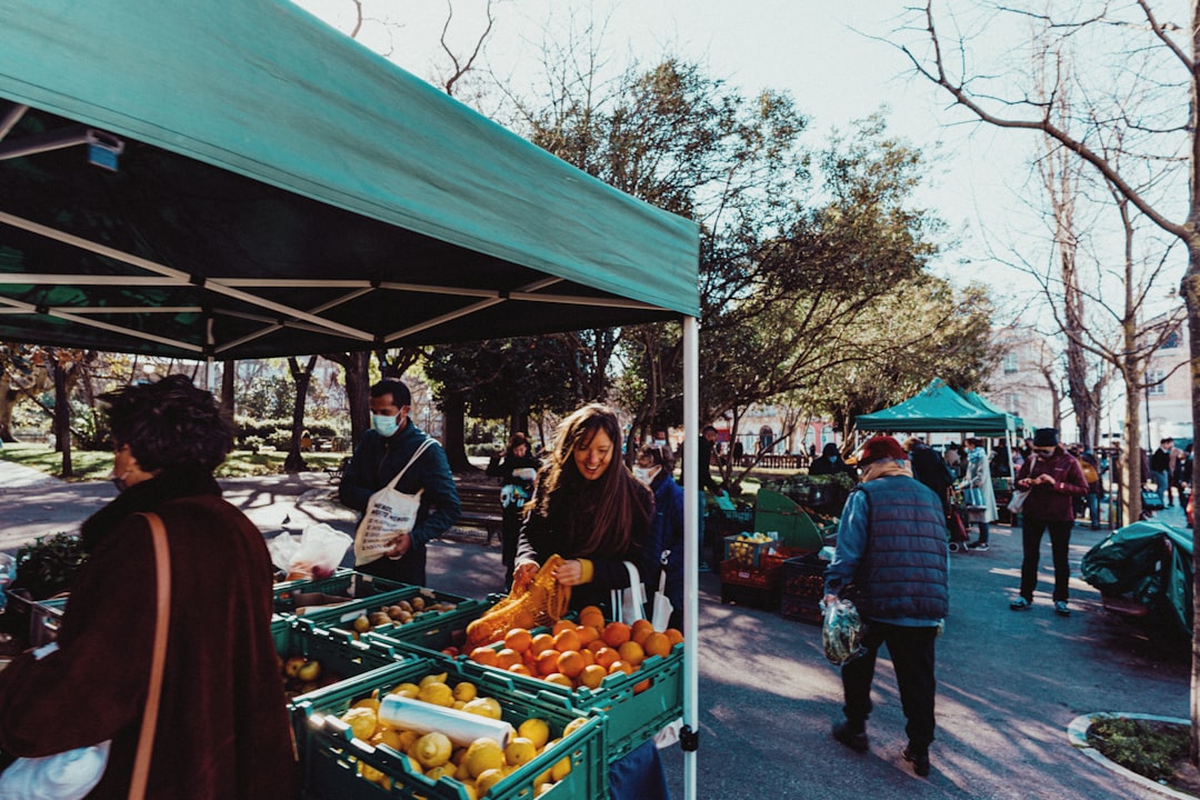 A chef selects root vegetables at a farmers market, choosing ingredients that reflect the seasonal shift toward autumn menus
