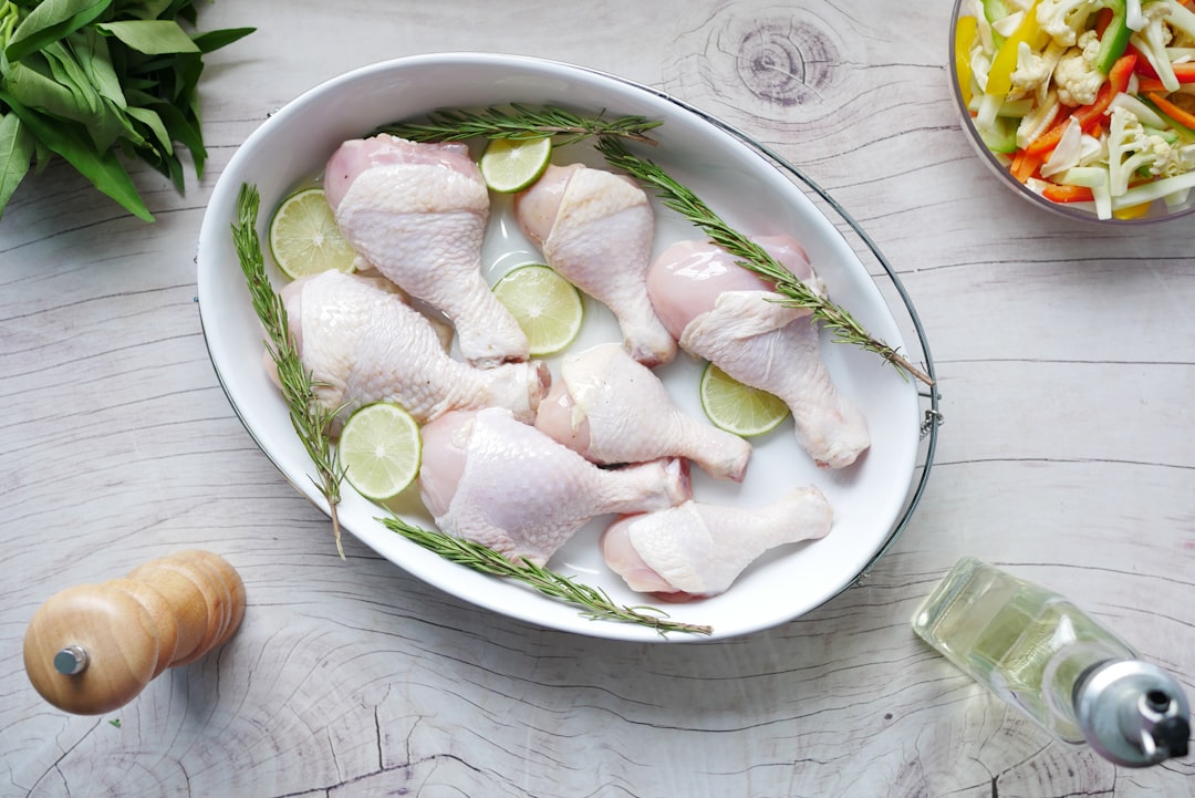 A home cook applying a marinade basics mixture to raw chicken pieces on a wooden board