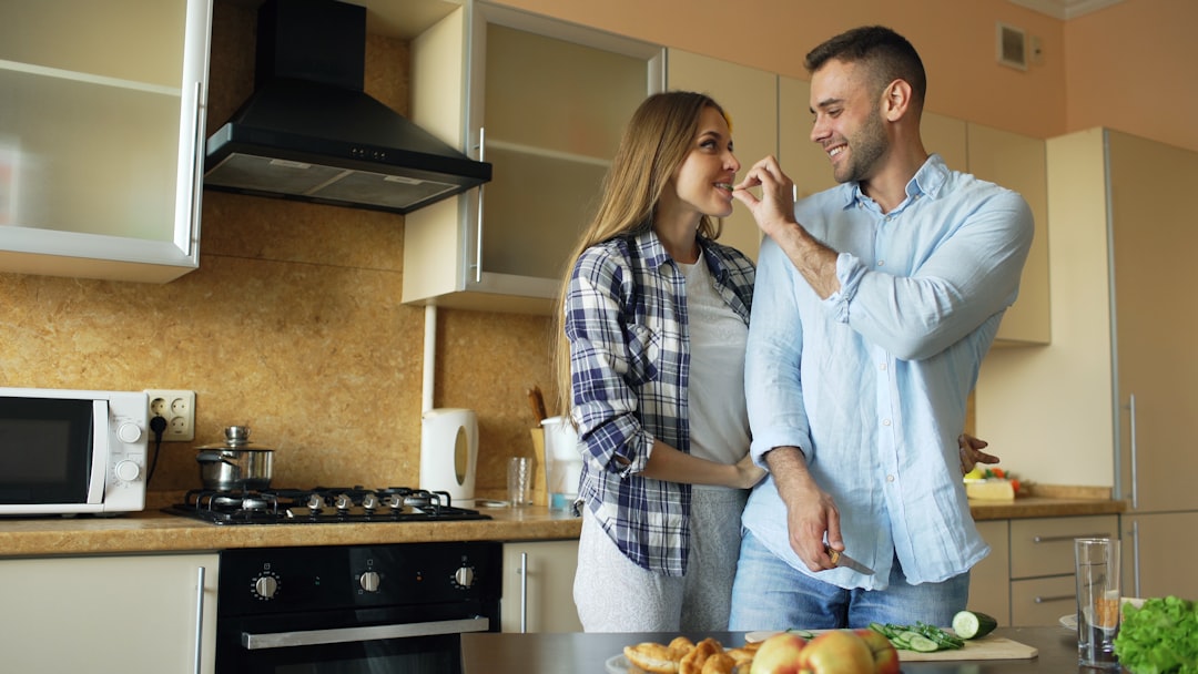 A smiling cook tasting a dish on the stovetop after choosing to adapt recipe instructions