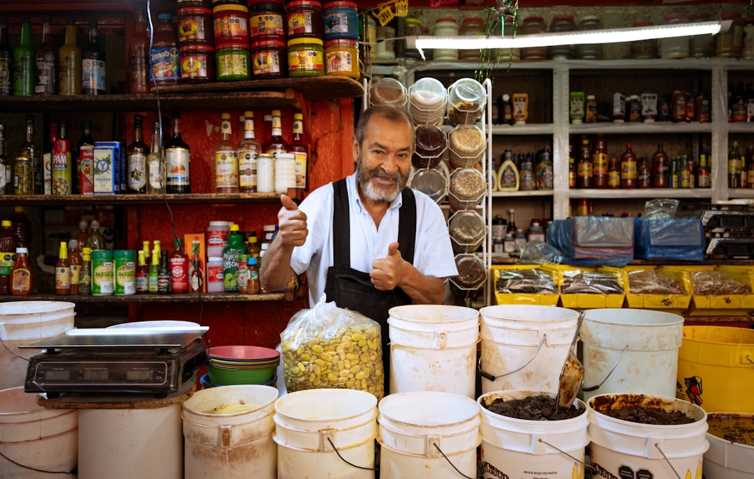 local spices at a market stall, exploring ingredient substitutions to adapt recipe flavors from another culture.