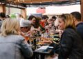 A chef carefully plates a dish for festival visitors, capturing the craft at the heart of British food culture in Edinburgh