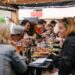 plating-dish-festival-crowd-unsplash - GUSTOwebzine Uno chef prepara con cura un piatto per i visitatori del festival, catturando l'artigianato al cuore della cultura culinaria britannica a Edimburgo