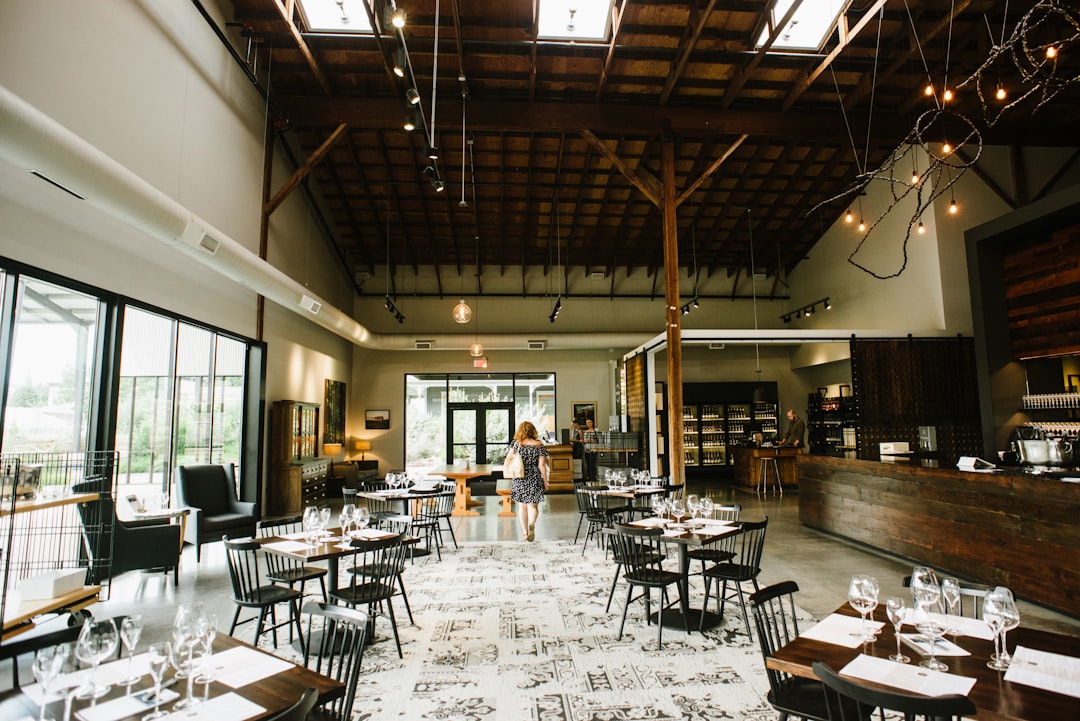 A server sets tables in a quiet dining room during the late August seasonal shift, adjusting pacing for fewer covers