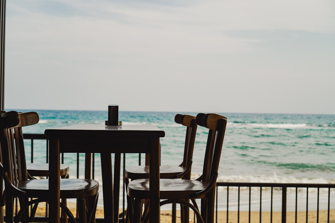 A server presents dishes to guests at a beachfront table, illustrating how resort menus adapt to the August tourist wave